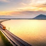 夕暮れの湖を走る列車 タイの鉄道風景